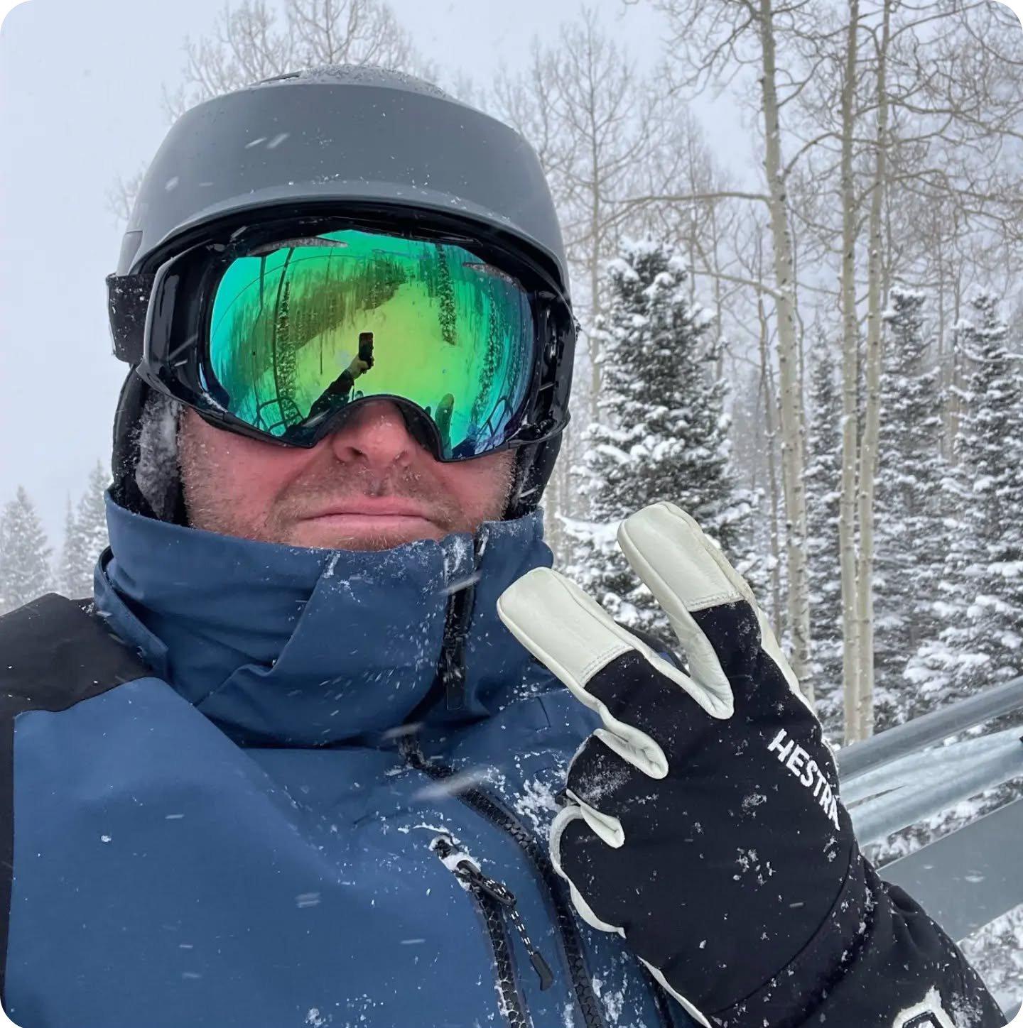 selfie of man outside in ski gear holding up a peace sign