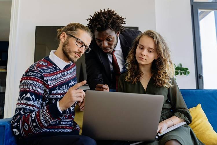Business people sitting on couch looking at laptop screen